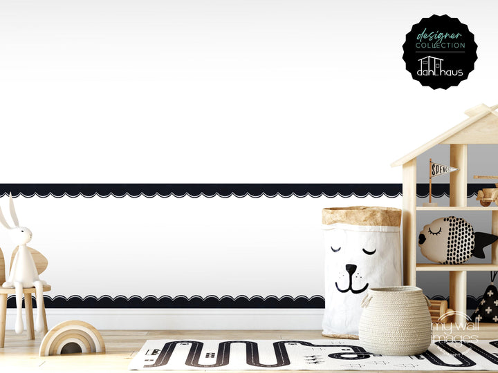 The image is a minimalist and modern children's room with a wooden shelf, a toy car, and a basket with a face on it. The room has a white and black color scheme, and the overall design appears clean and simple.