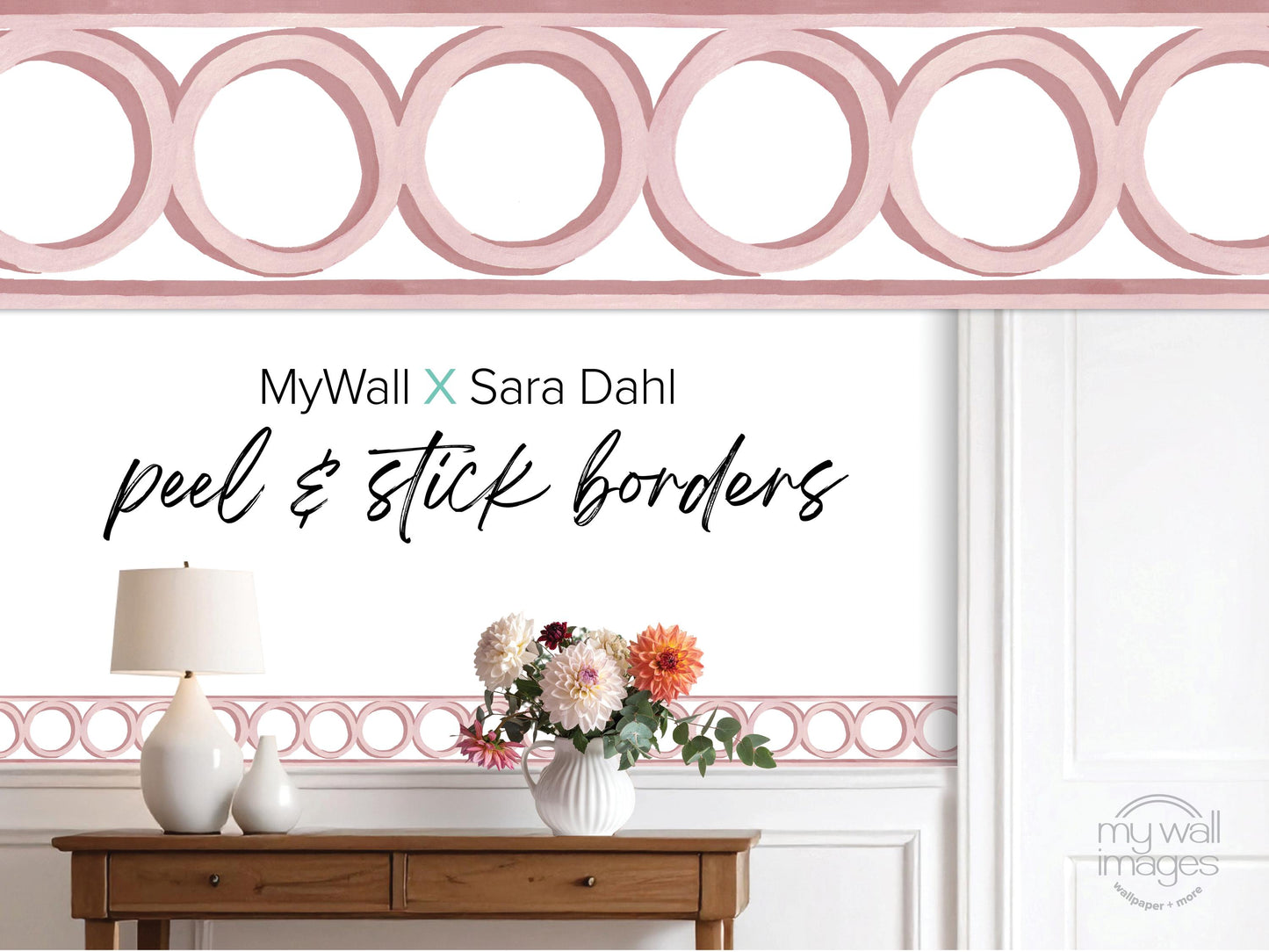 a wooden table with a vase of flowers, a lamp, and a pink border with circular shapes. The text above the table reads "MyWall X Sara Dahl peel & stick borders".
