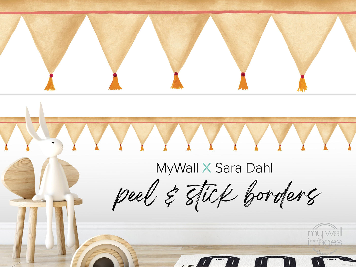 a white rabbit sitting on a wooden chair, with a wall decorated with orange and white tassels. The wall has a text overlay that reads "MyWall x Sara Dahl Peel & Stick Borders".