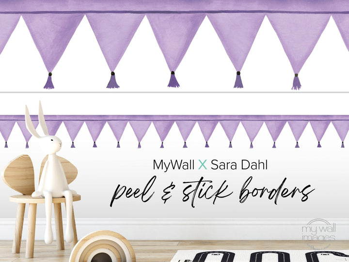 a white rabbit sitting on a wooden chair, with a purple banner featuring tassels hanging above it. The banner is described as "MyWall X Sara Dahl peel & stick borders".