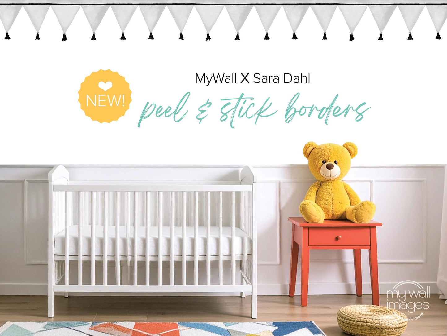 a nursery room with a white crib, a yellow teddy bear, and a red table. The crib is positioned against a white wall, and the teddy bear is sitting on the table. The room has a geometric patterned rug on the floor.