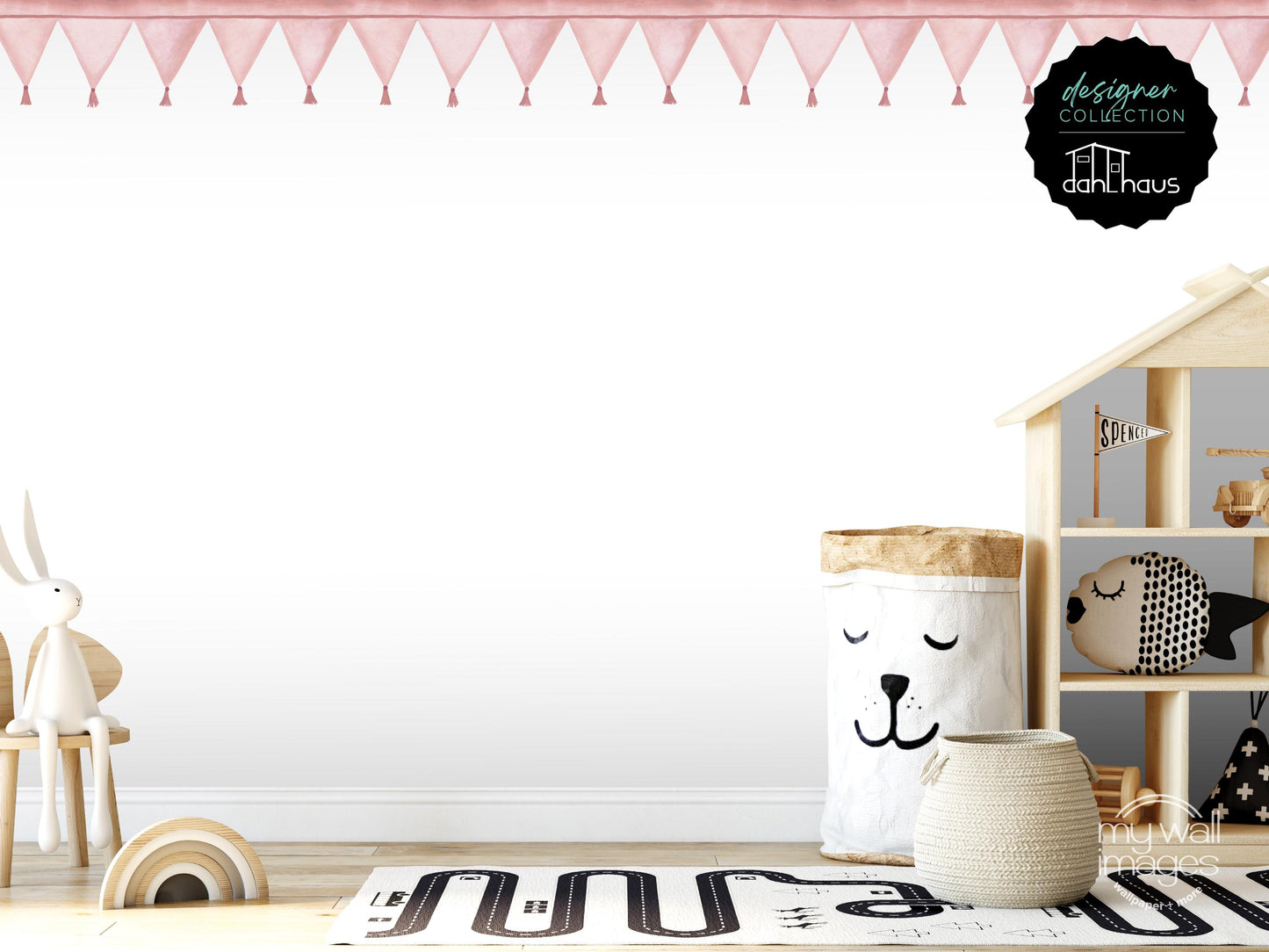 A child's bedroom with a wooden playhouse, a stuffed animal rabbit, and a basket with a face on it. The room has a pink and white color scheme, and there are various toys and decorations.