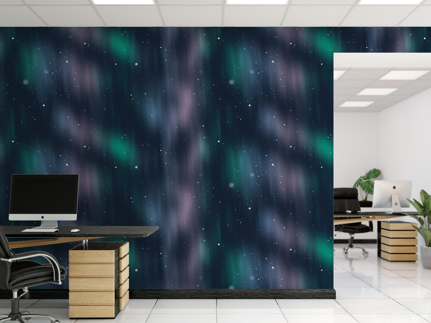 a modern office space with a large wall mural featuring a starry night sky. The office has a desk with a computer setup, including a monitor, keyboard, and mouse. The room also includes a plant and a chair, creating a comfortable and visually appealing workspace.