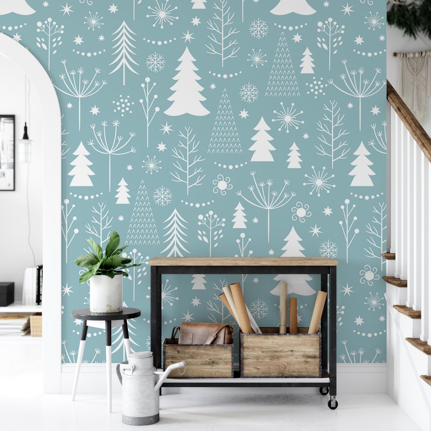 a room with a blue wall decorated with white snowflakes and trees. In the foreground, there is a wooden table with a plant on it, and a metal shelf holding some items.