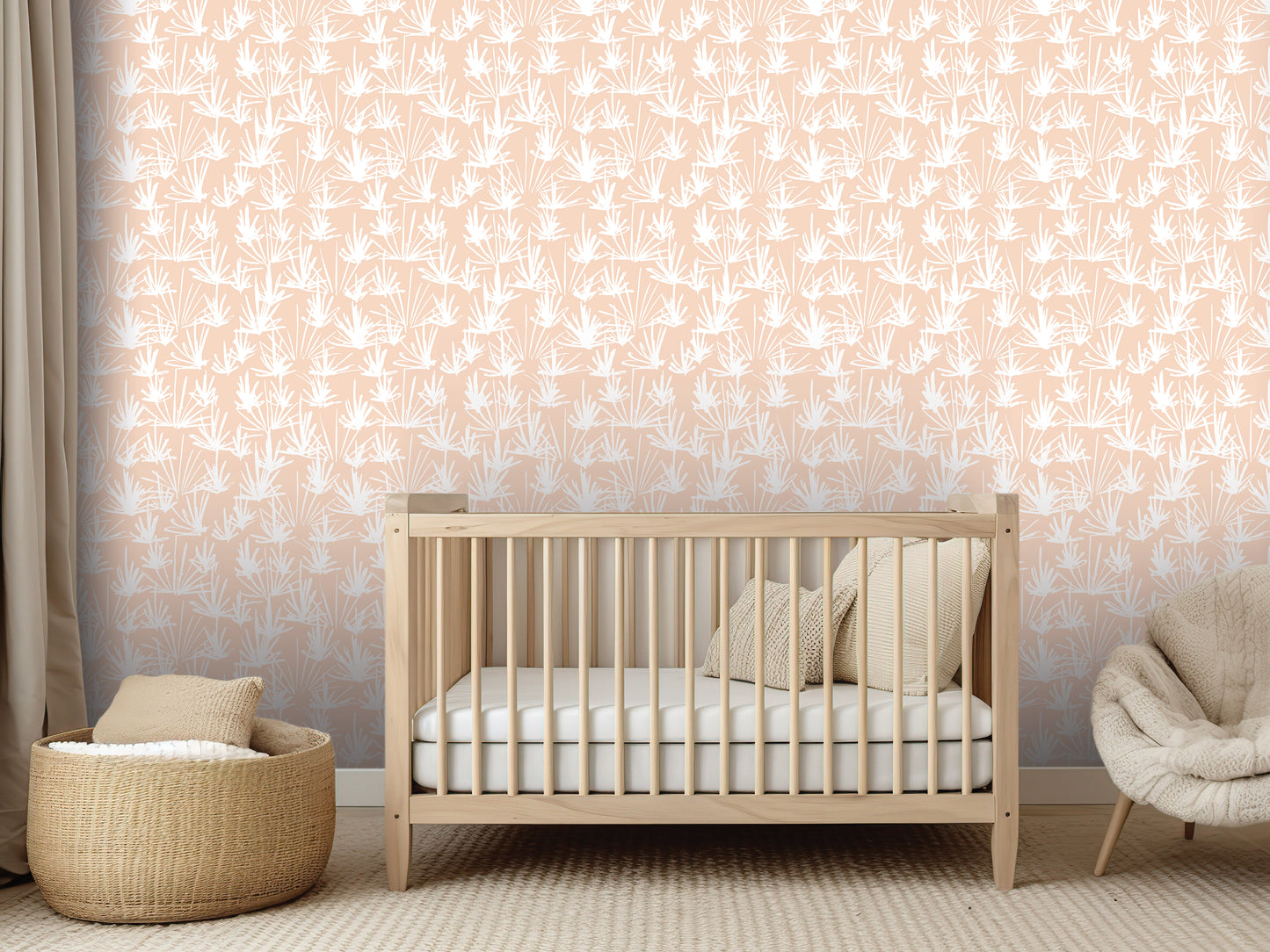 a nursery room with a wooden crib, a woven basket, and a plush chair. The room has a peach-colored wall with a repeating pattern of white palm leaves.