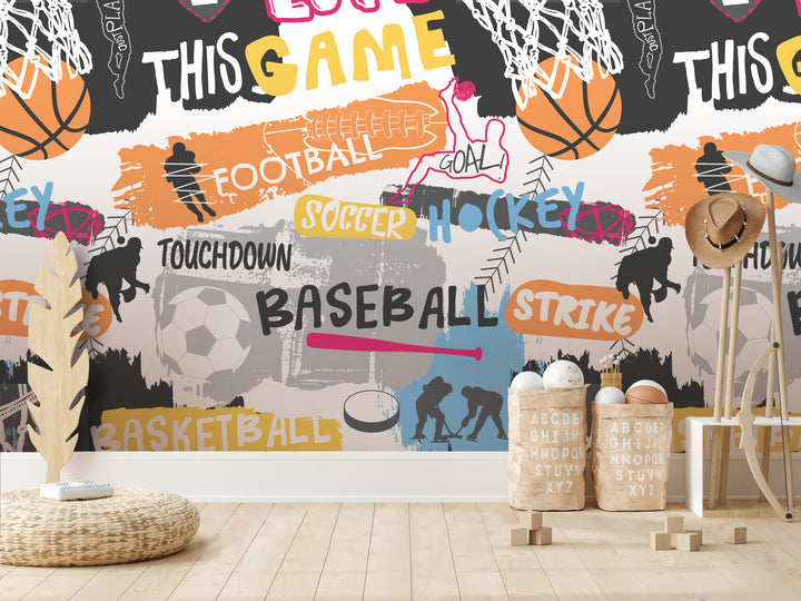 a wall with a collage of various sports-related images, including basketball, soccer, hockey, and baseball, along with the words "TOUCHDOWN", "SOCcer", "HOCKEY", "BASEBALL", and "STRIKE". There are also some wooden crates or baskets in the foreground, and a wicker basket on the floor.