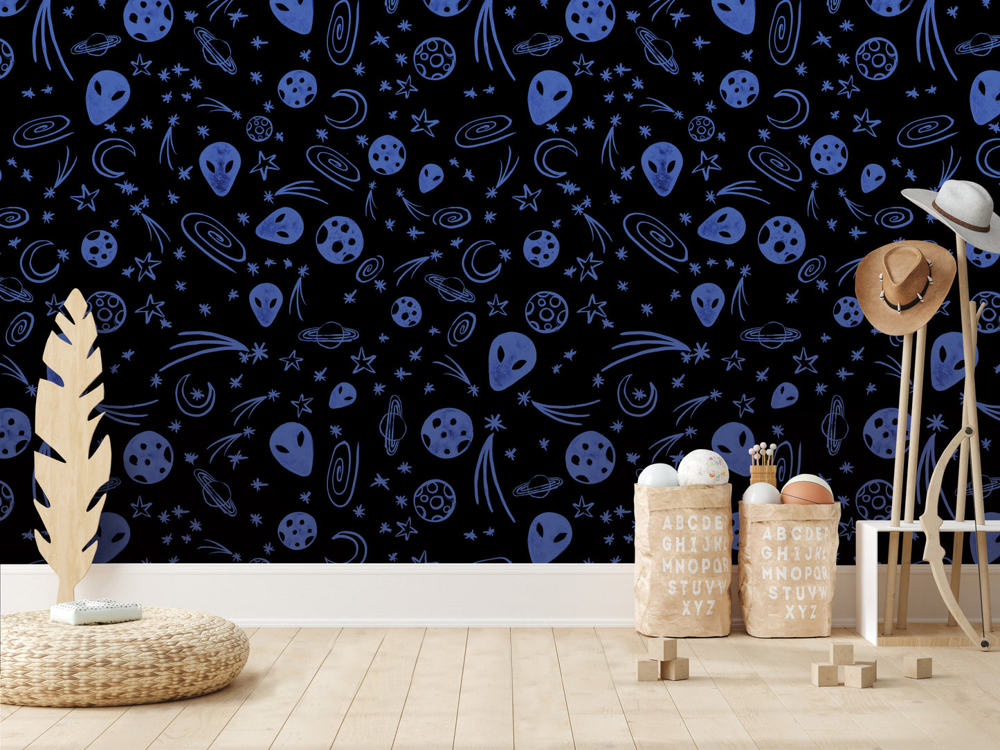 a wallpapered wall with a pattern of blue and white celestial objects, including planets, stars, and comets. In the foreground, there are two wooden stools and a wicker basket, and a wooden structure with a hat on top.