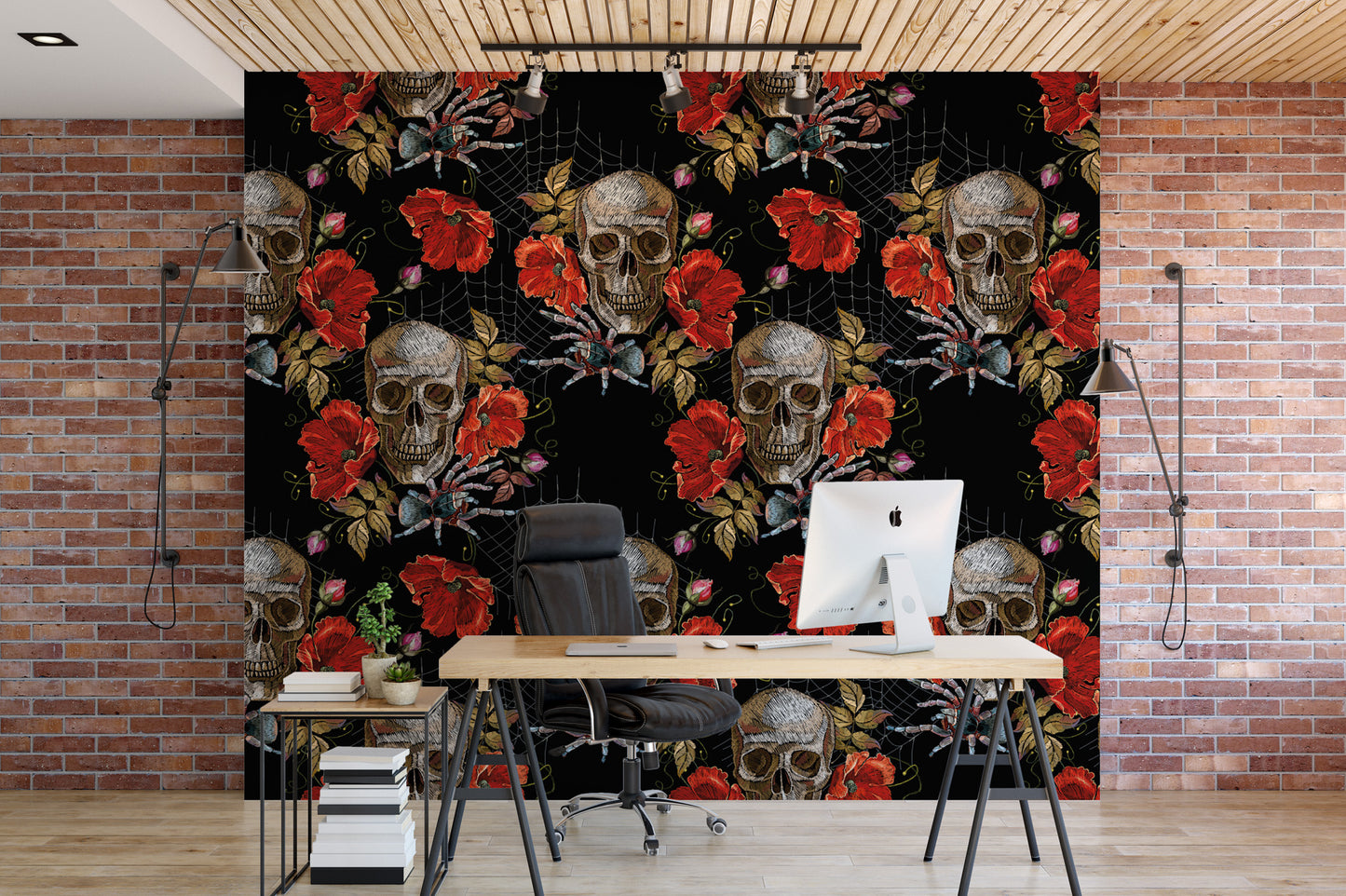 a modern office space with a large wall mural depicting a repeating pattern of skulls and red roses. In the foreground, there is a wooden desk with a computer monitor, a black office chair, and a small side table.