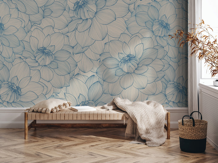 a living room with a large blue floral wallpaper on the wall behind a wooden bench. The bench is positioned in front of a window, and there is a woven basket on the floor next to it.