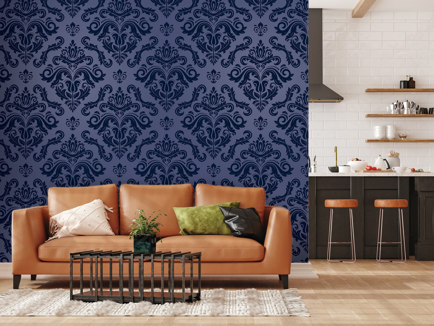 a living room with a brown leather sofa, a coffee table, and a rug. The wall behind the sofa has a blue damask pattern, and there are shelves with various items on them. In the background, there is a kitchen area with a countertop and stools.