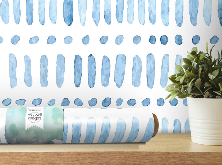 a roll of blue and white striped wallpaper with a plant in a white pot placed on a wooden shelf.
