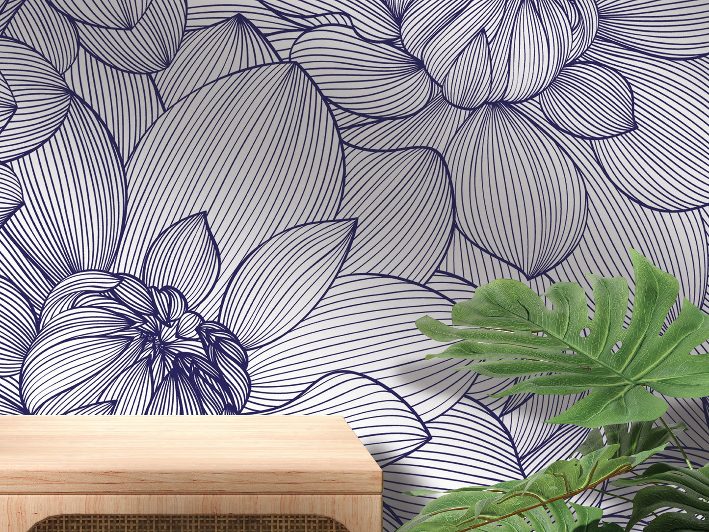 a wallpapered wall with a floral pattern, a wooden table, and some green plants.