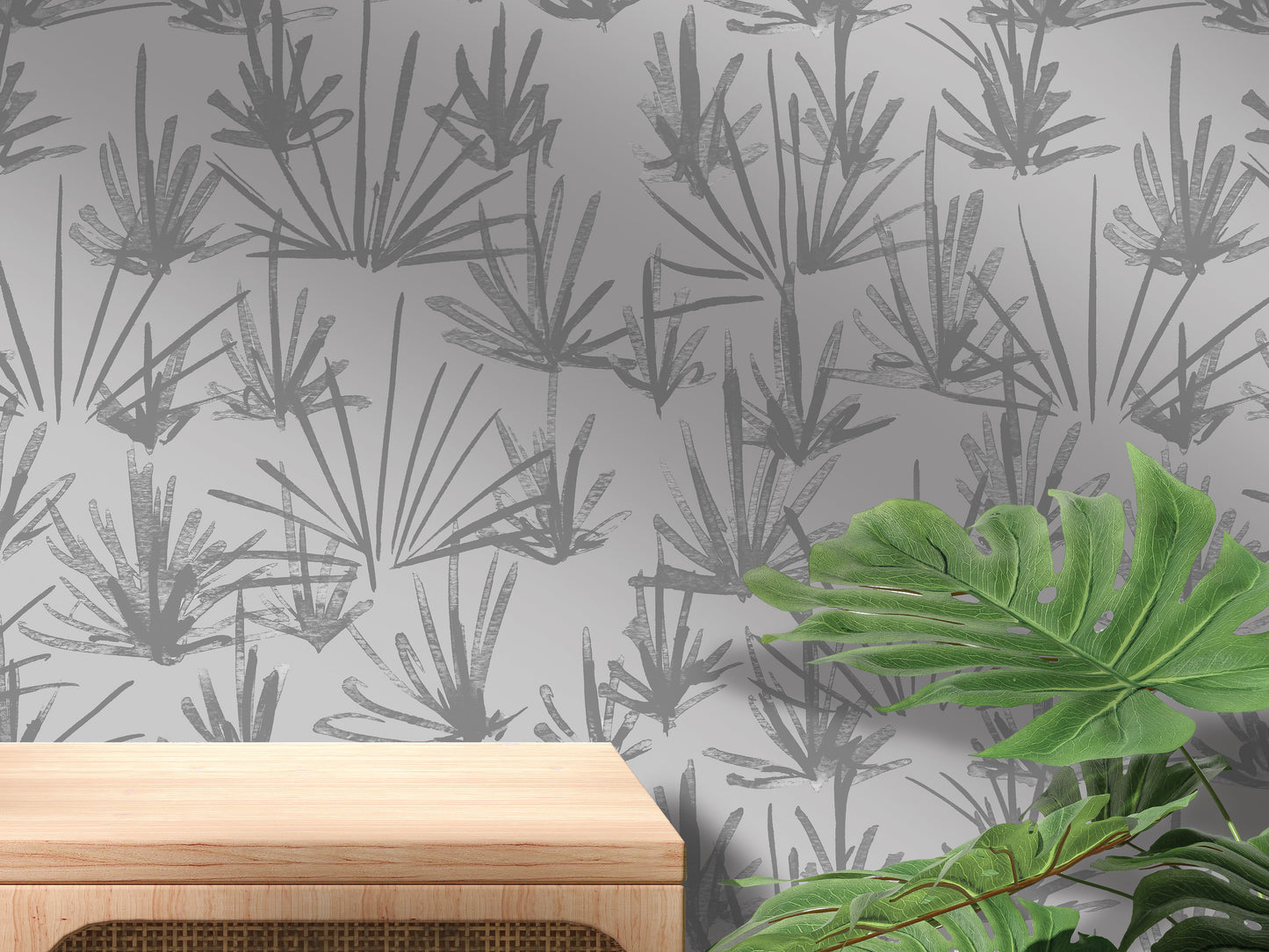 a gray wall with a repeating pattern of stylized plant leaves in shades of gray and black. In front of the wall, there is a wooden table with a leafy plant on top of it.