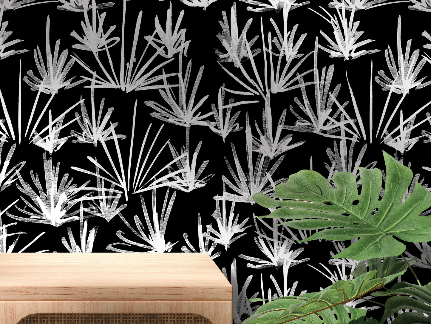 a black and white pattern of stylized leaves and plants on a wall, with a wooden table in the foreground.