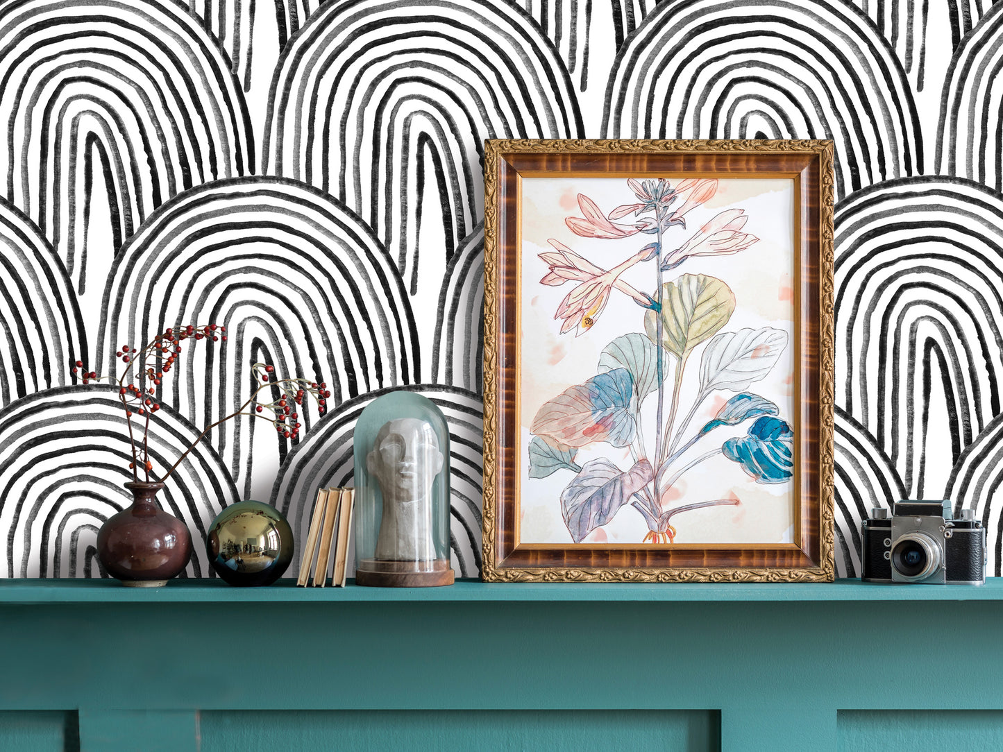 a shelf with various decorative items, including a framed drawing of a plant, a vase, a glass dome, and a camera. The shelf has a teal color and is set against a black and white striped background.