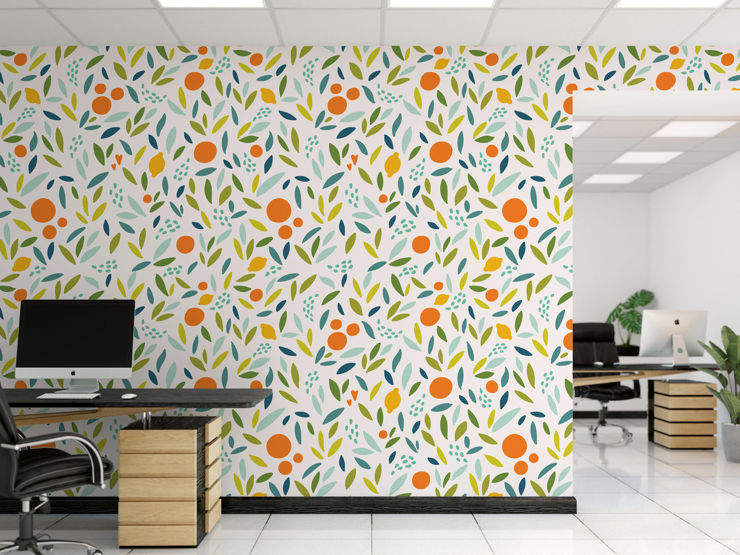 a modern office space with a vibrant wall mural depicting a pattern of orange and green leaves and circles. The office has two desks, one with a computer monitor and the other with a chair. The room also includes potted plants and a large window, creating a bright and welcoming atmosphere.