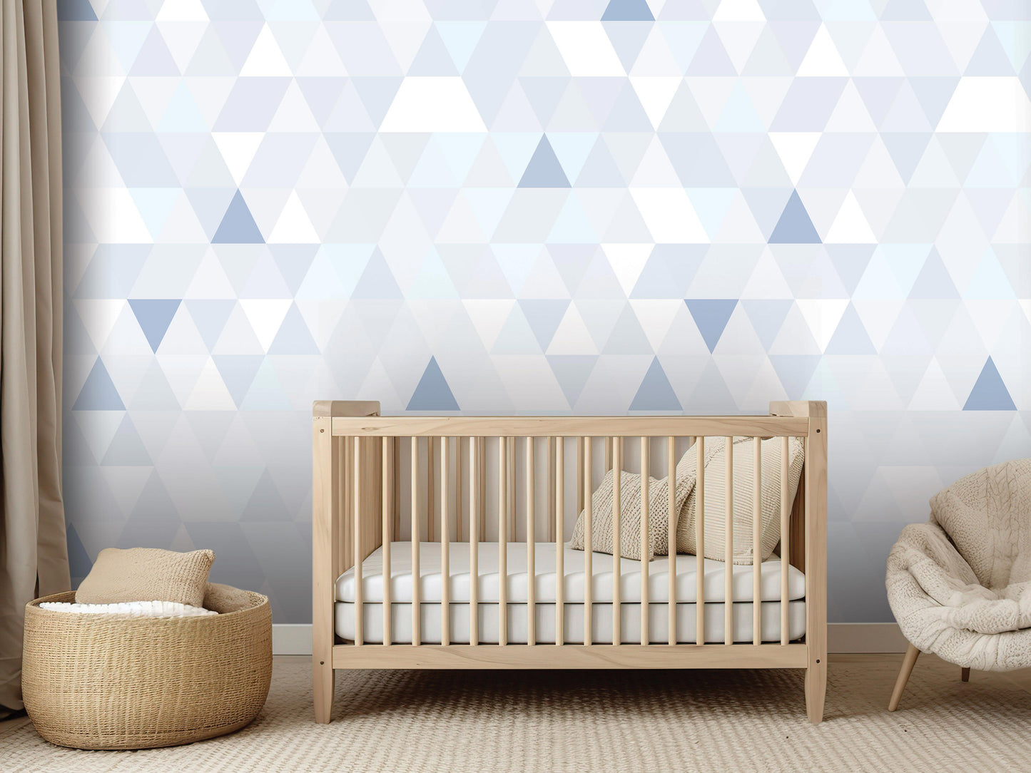 a modern nursery with a wooden crib, a beige chair, and a woven basket. The crib is positioned against a wall with a geometric pattern in shades of blue and gray.