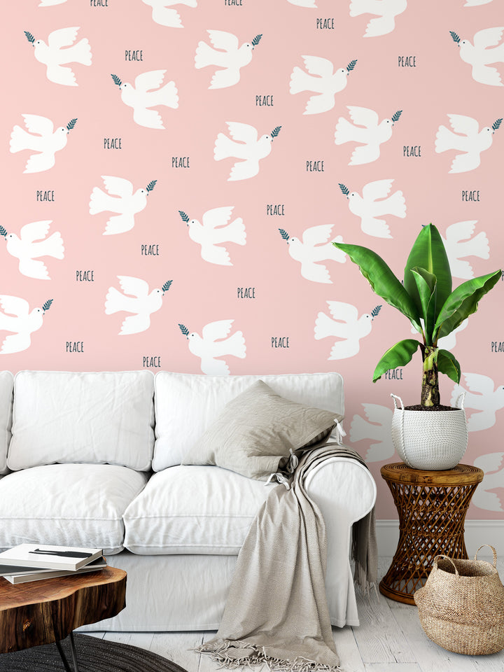 a living room with a white sofa, a wooden side table, and a potted plant. The wall behind the sofa has a repeating pattern of white doves and the word "Peace" written on it.