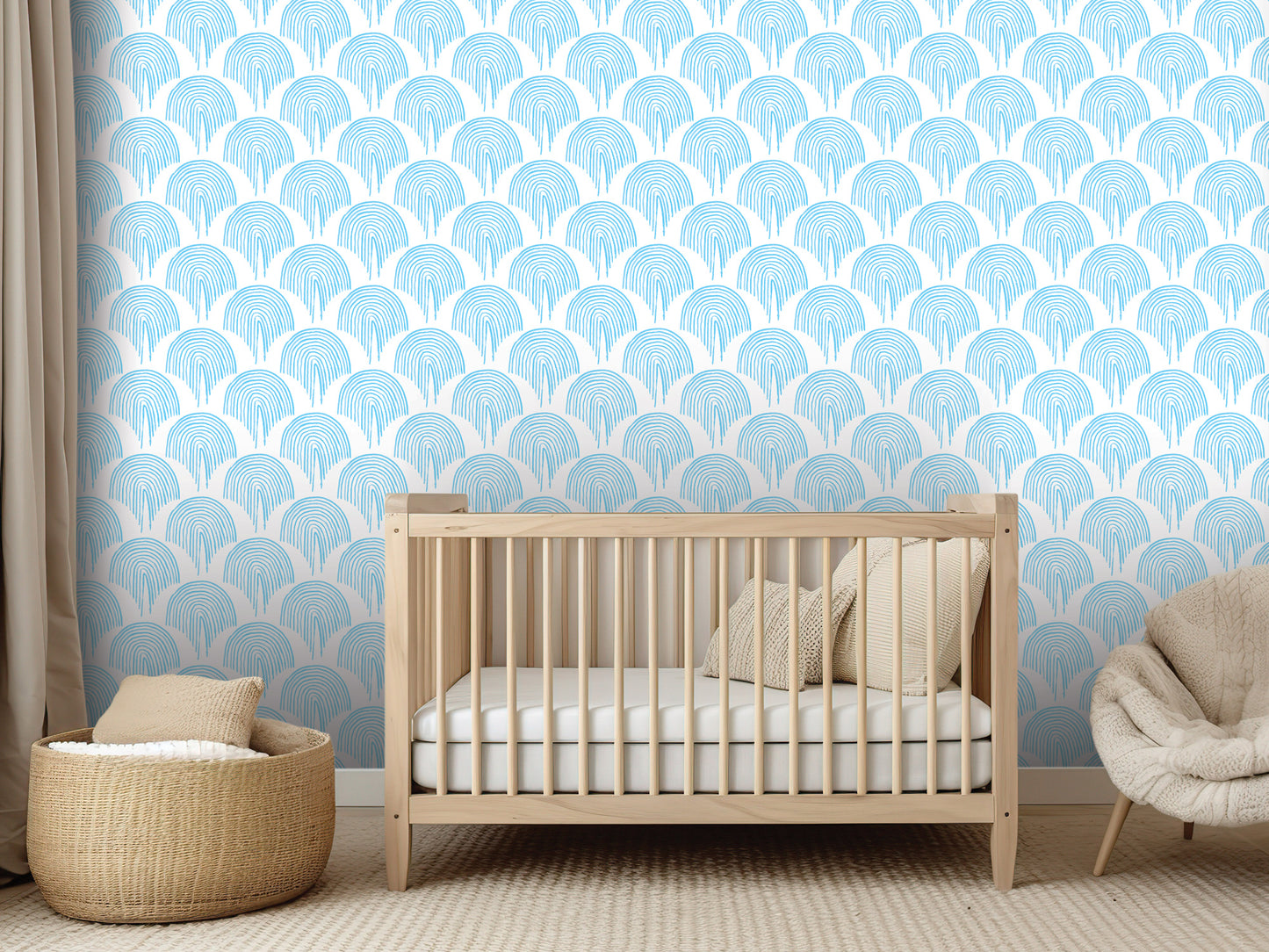 a nursery room with a wooden crib, a woven basket, and a plush chair. The crib is positioned against a wall with a repeating pattern of blue and white circles.