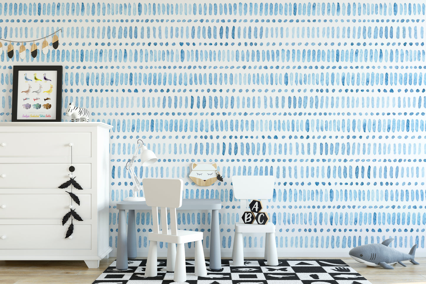 a child's bedroom with a white dresser, a table with chairs, and a wallpapered wall with a blue and white pattern.