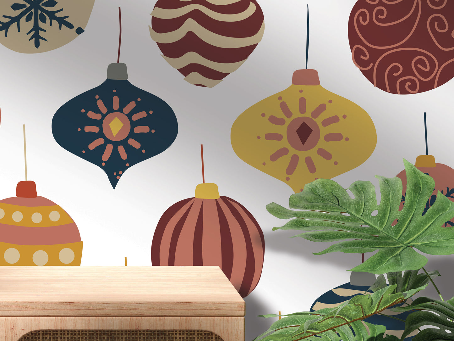 a wall adorned with a variety of colorful Christmas ornaments, including baubles, stars, and other festive decorations. The ornaments are arranged in a visually appealing manner, creating a festive atmosphere. In the foreground, there is a wooden table, and a plant can be seen in the background, adding a touch of greenery to the scene.