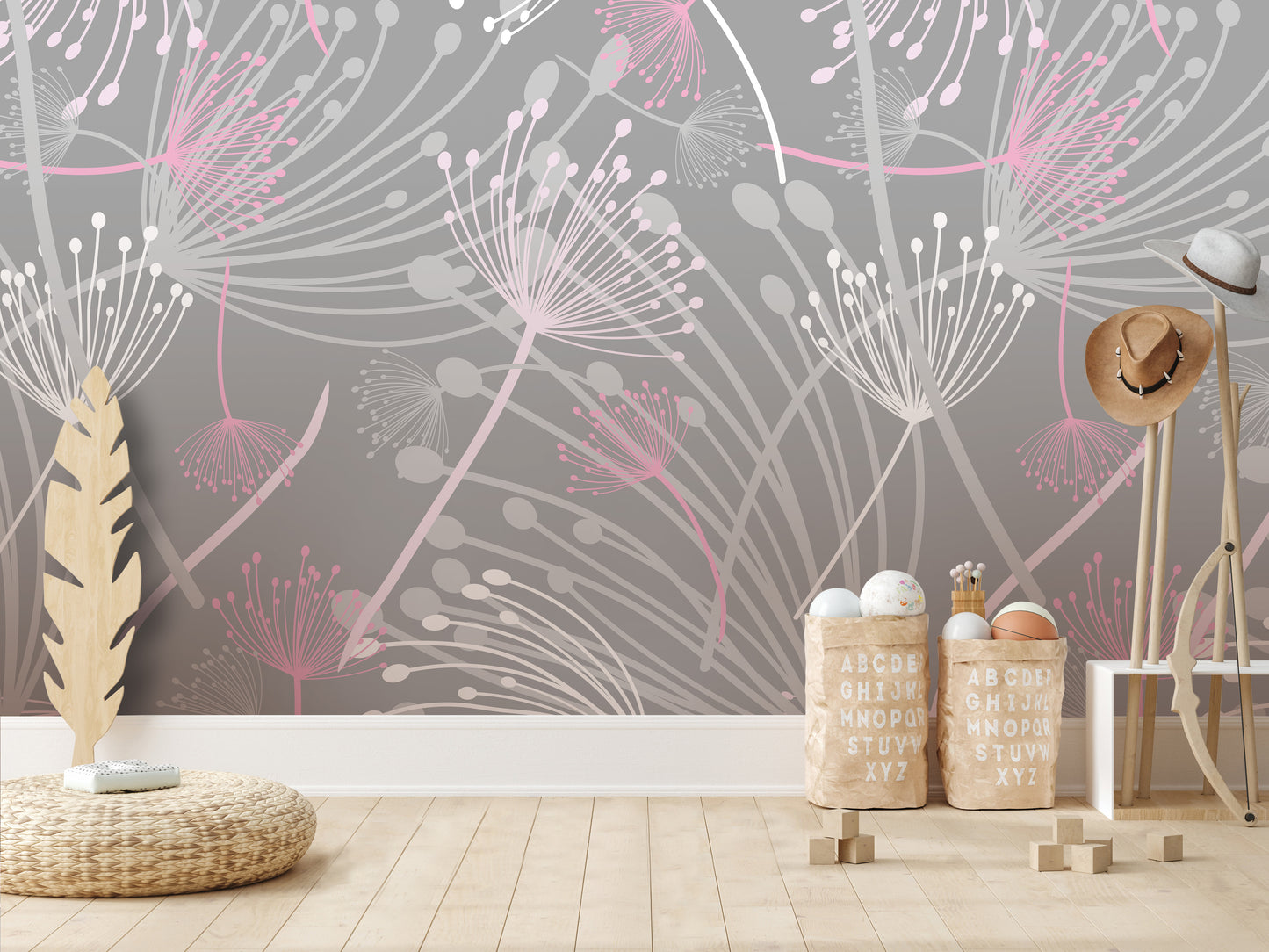 a room with a gray and pink floral pattern on the wall, a wicker floor mat, and a wooden stool with a hat on it. There are also two wooden crates with alphabet letters on them, and a feather decoration.