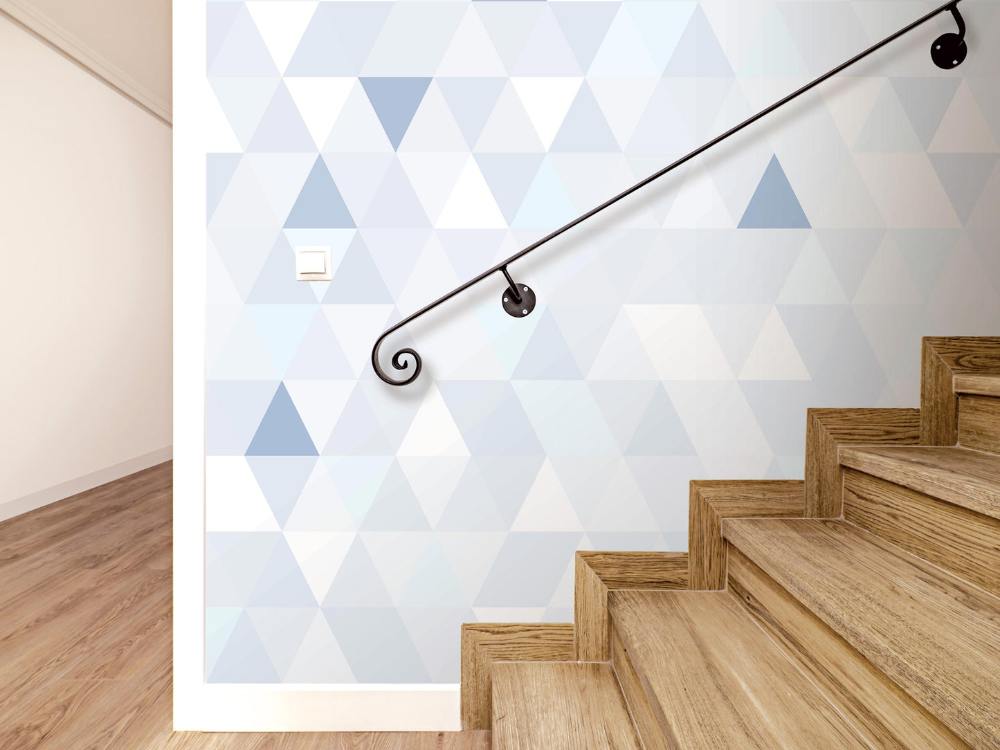 a staircase with wooden steps and a black metal handrail, set against a wall with a geometric pattern in shades of blue and white.