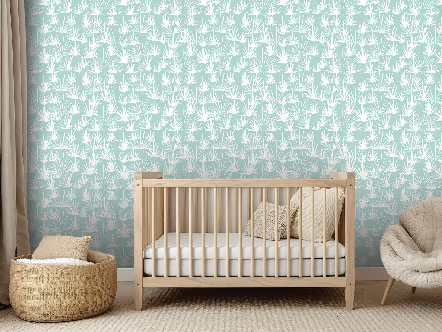 a nursery room with a wooden crib, a woven basket, and a beige chair. The crib is positioned against a wall with a repeating pattern of white leaves.