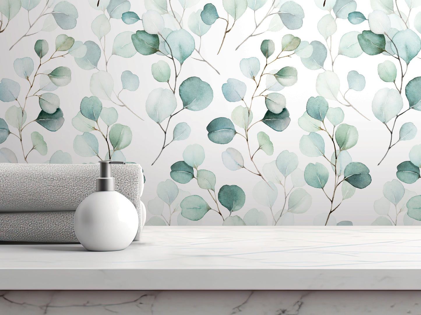 a white shelf with a white soap dispenser and a folded towel, set against a wall with a watercolor-style wallpaper pattern of green leaves.