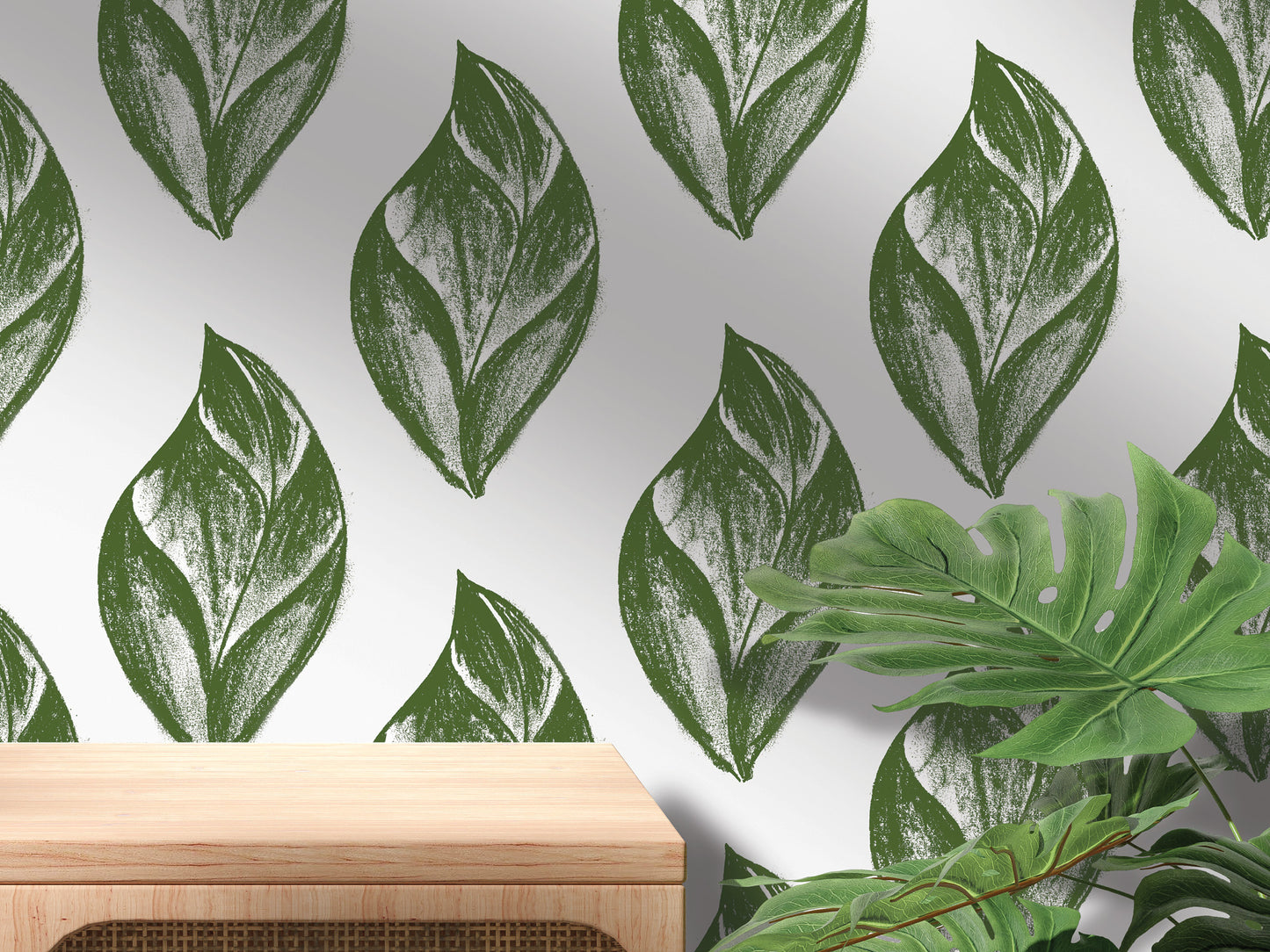 a wall with a repeating pattern of green leaf-like designs, creating a natural and organic aesthetic. In the foreground, there is a wooden table, and in the background, there are several large green leaves, possibly from tropical plants.