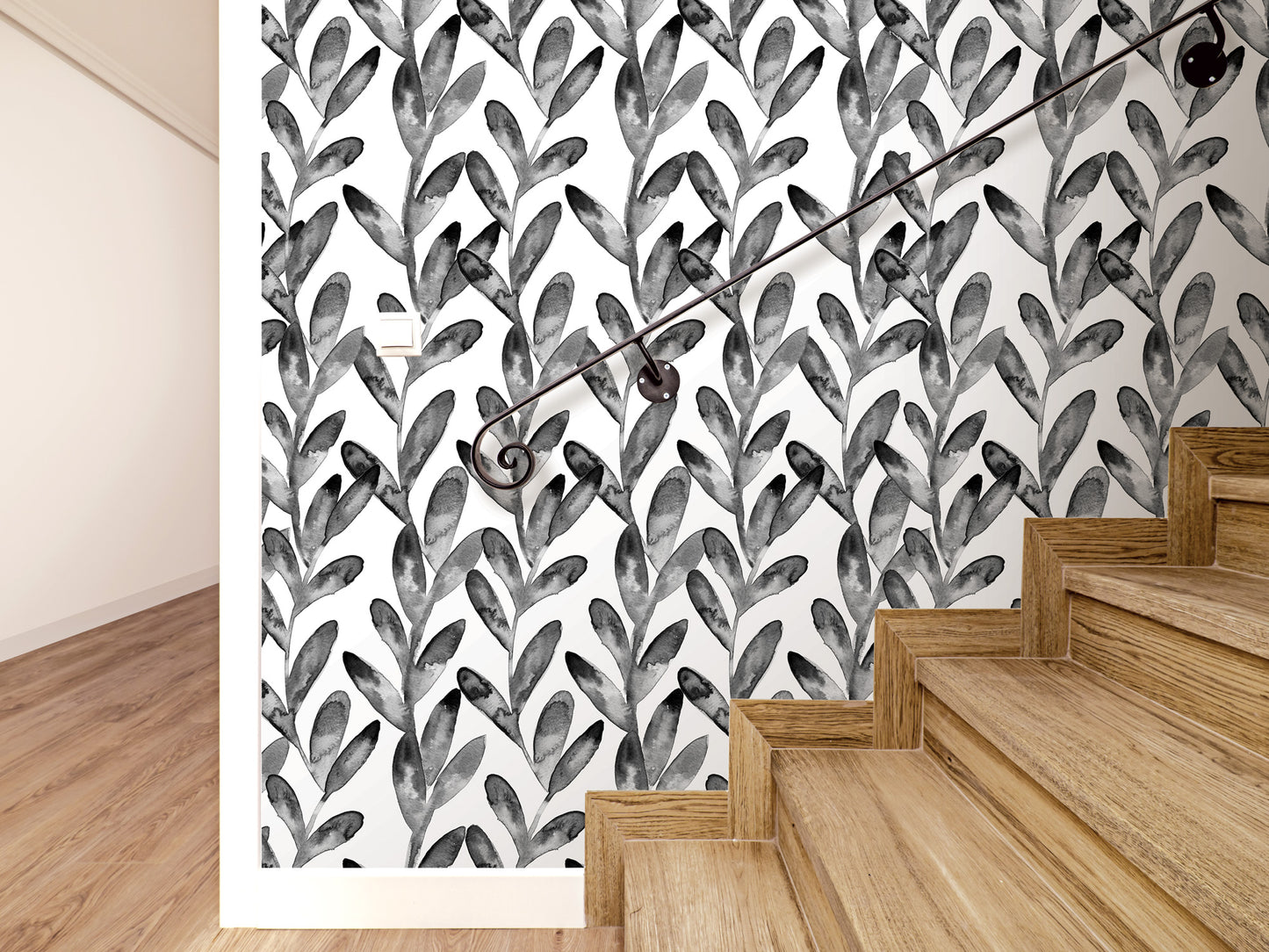 a wall with a black and white leaf pattern wallpaper, and a wooden staircase with a metal handrail.