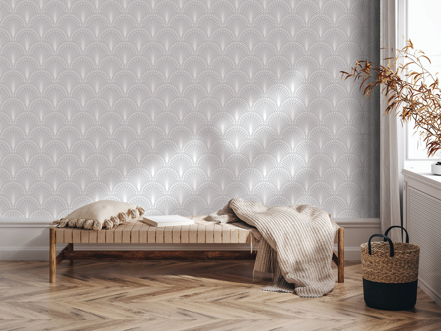 a modern and minimalist living room with a wooden floor and a bench with a pillow and blanket on it. The wall behind the bench has a repeating pattern of gray and white circles, creating a visually appealing backdrop. A woven basket is placed next to the bench, and a plant is visible in the corner of the room.