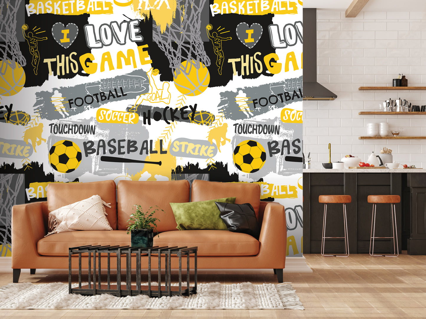 a living room with a brown leather couch, a coffee table, and a kitchen area with a counter and stools. The wall behind the couch is covered in a vibrant, graffiti-style wall mural with various sports-related words and images, including "BASKETBALL", "FOOTBALL", "SOCcer", "HOCKEY", "TOUCHDOWN", "BASEBALL", "STRIKE", and "BALL".