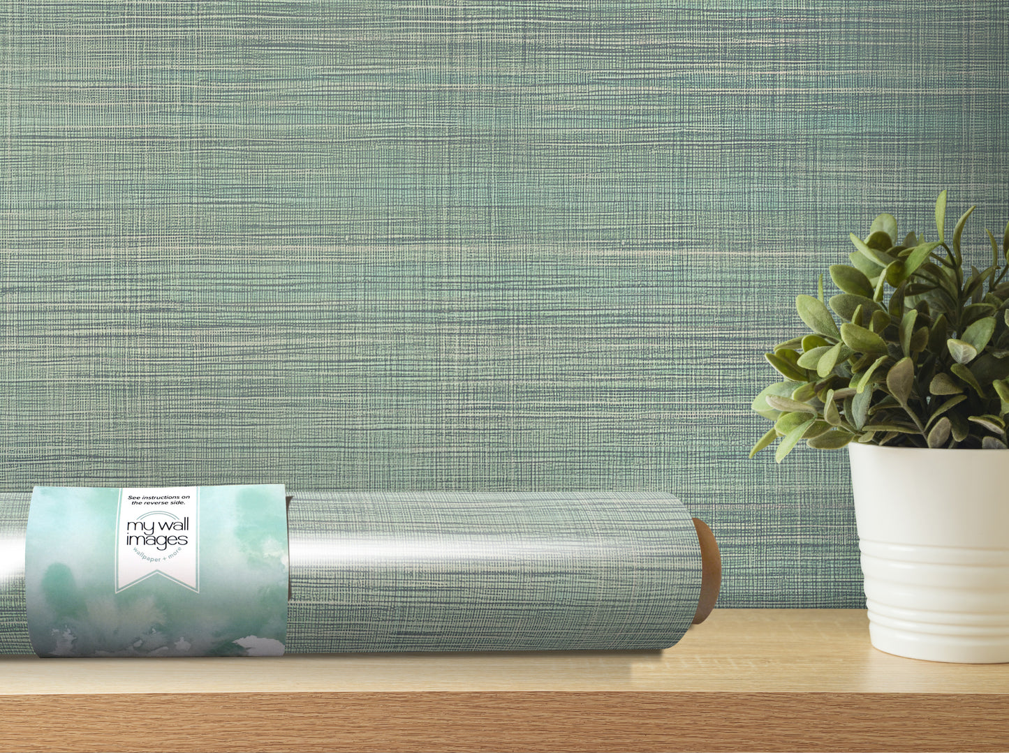 a roll of wallpaper with a label, a potted plant, and a wooden shelf against a textured green background.