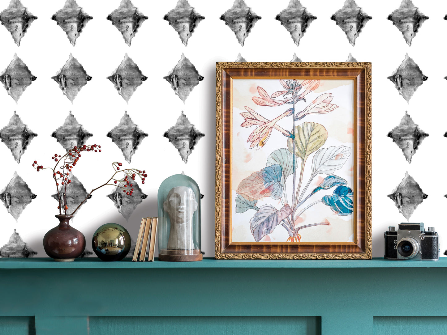 a shelf with various decorative items, including a framed drawing of a plant, a vase with flowers, a glass dome, and a camera. The shelf has a teal color and is set against a white wall with a black and white diamond pattern.