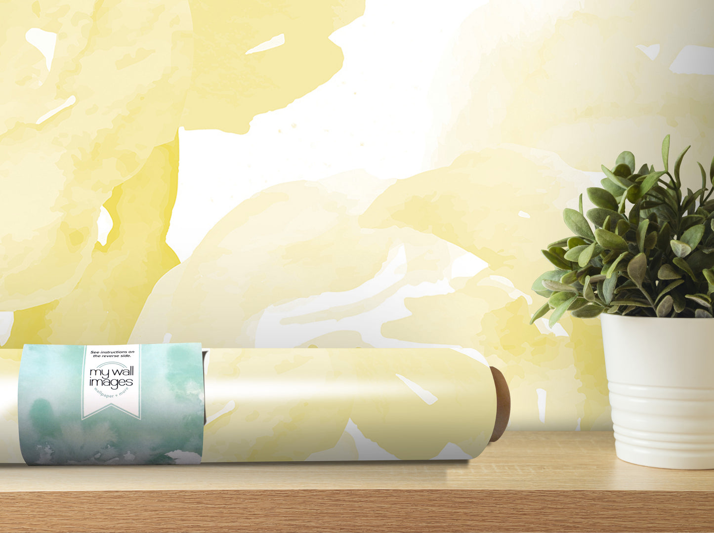 a roll of wallpaper with a watercolor-like pattern, placed on a wooden shelf next to a potted plant.