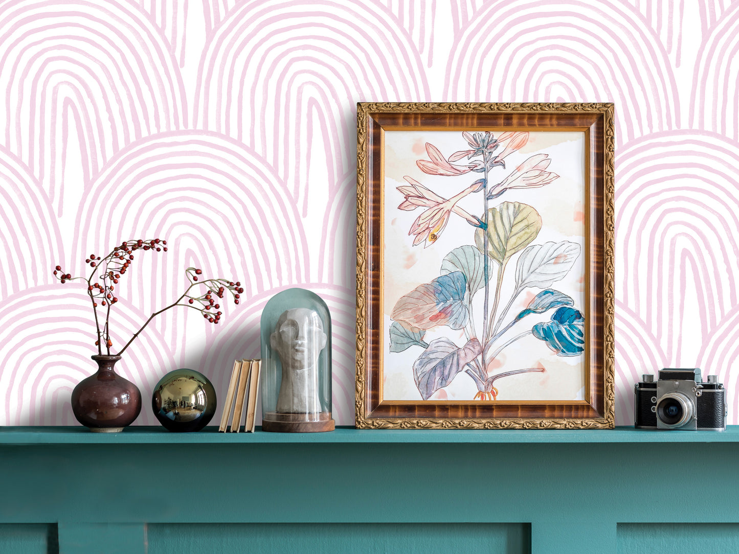 a shelf with various decorative items, including a framed botanical drawing, a vase with flowers, a glass dome, a camera, and a stack of books.
