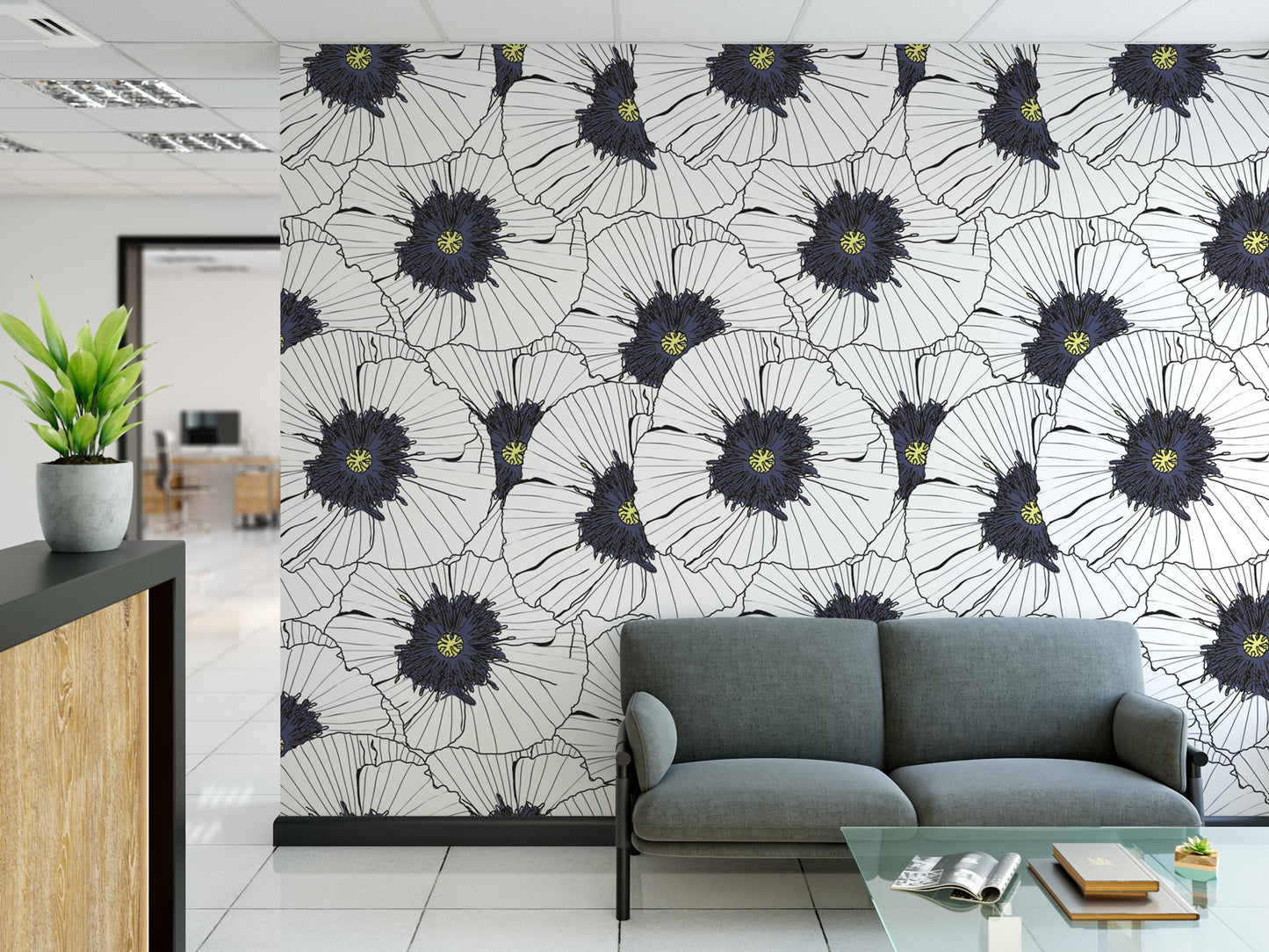 a modern office space with a large wall mural of white and black flowers, a gray sofa, and a glass coffee table.
