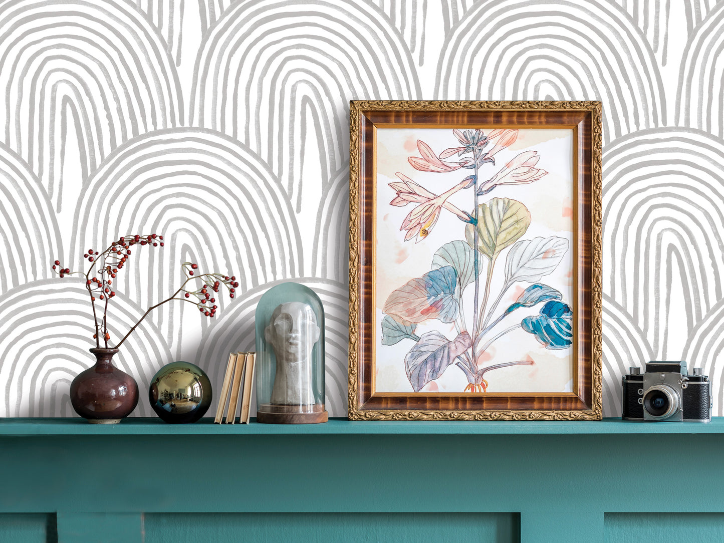 a shelf with various decorative items, including a framed picture of a plant, a vase with flowers, a glass dome, a camera, and a stack of books.