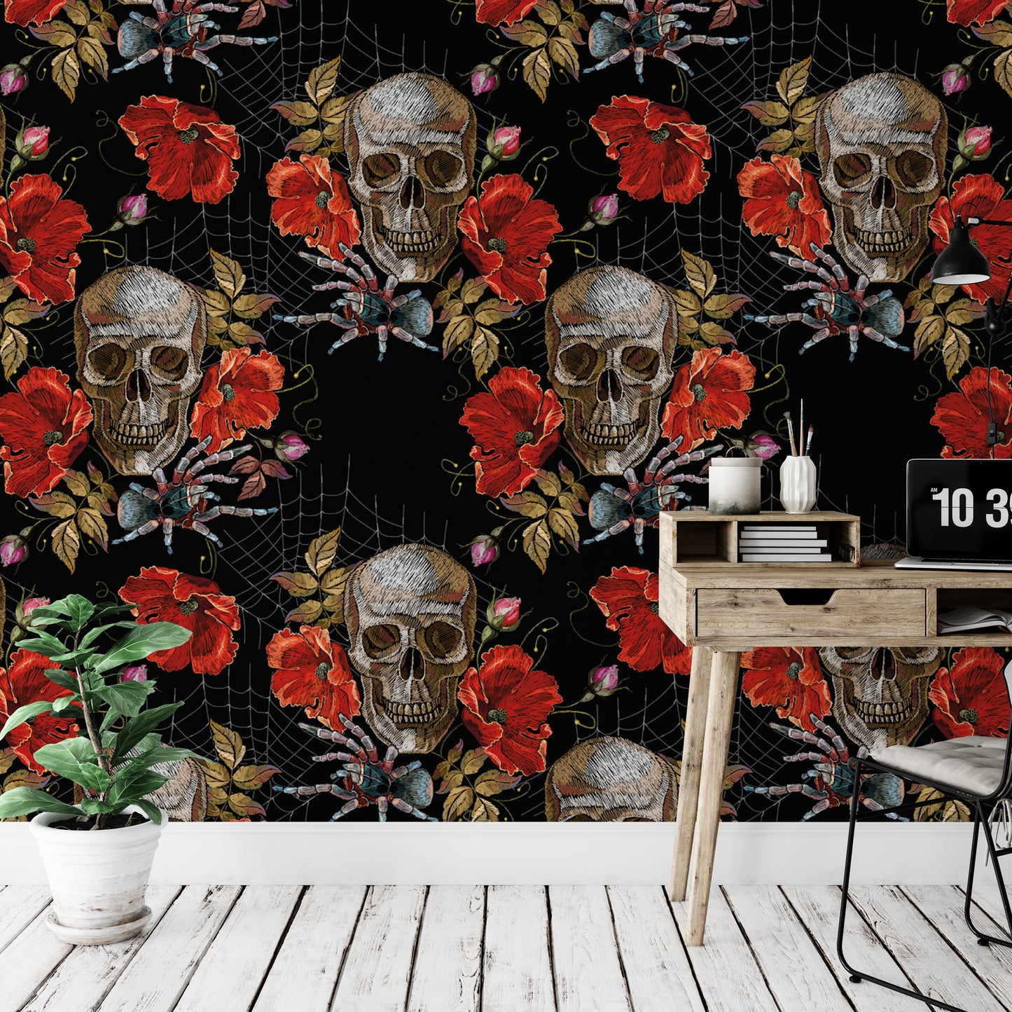 a wallpapered wall with a repeating pattern of skull and flower designs in red and black. There is a wooden desk with a laptop and a plant in the foreground, and a spider web pattern is visible on the wall.