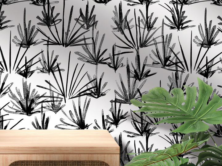 a wall with a black and white pattern of stylized plants or leaves, and a wooden table or shelf is visible in the foreground.