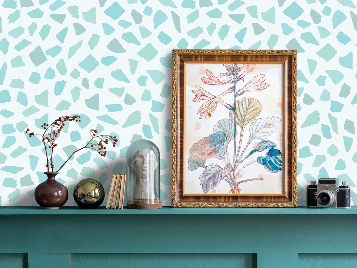 a shelf with various decorative items, including a framed drawing of a plant, a vase with flowers, a glass dome, and a camera.