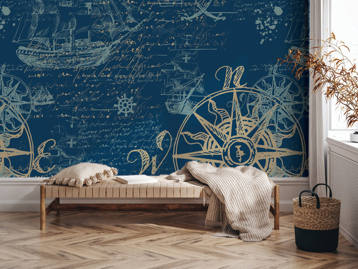 a room with a large blue wall mural depicting a ship and a compass. In the foreground, there is a wooden bench with a blanket draped over it, and a woven basket next to it.