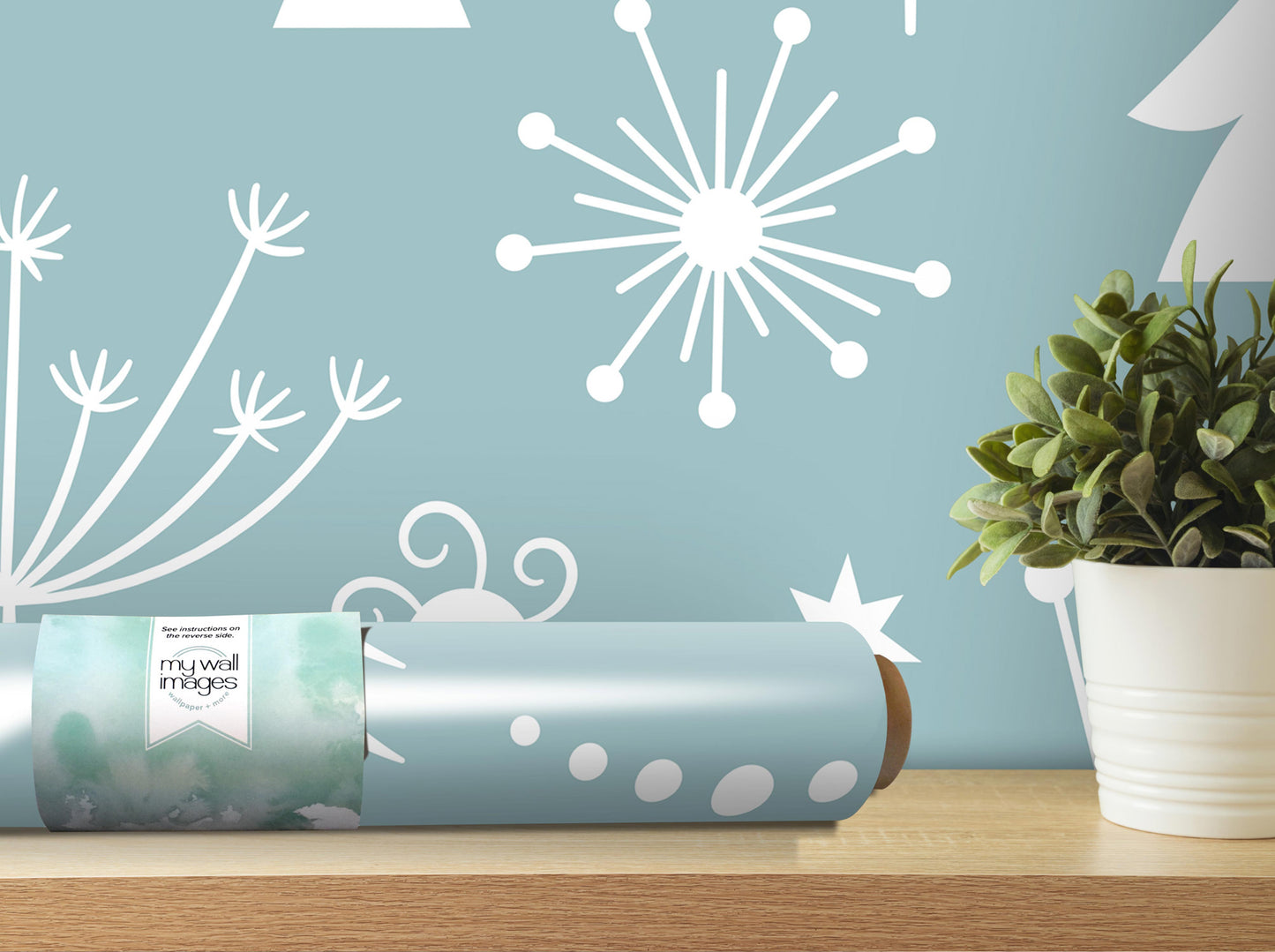a blue wall with white snowflake designs and a potted plant on a shelf.