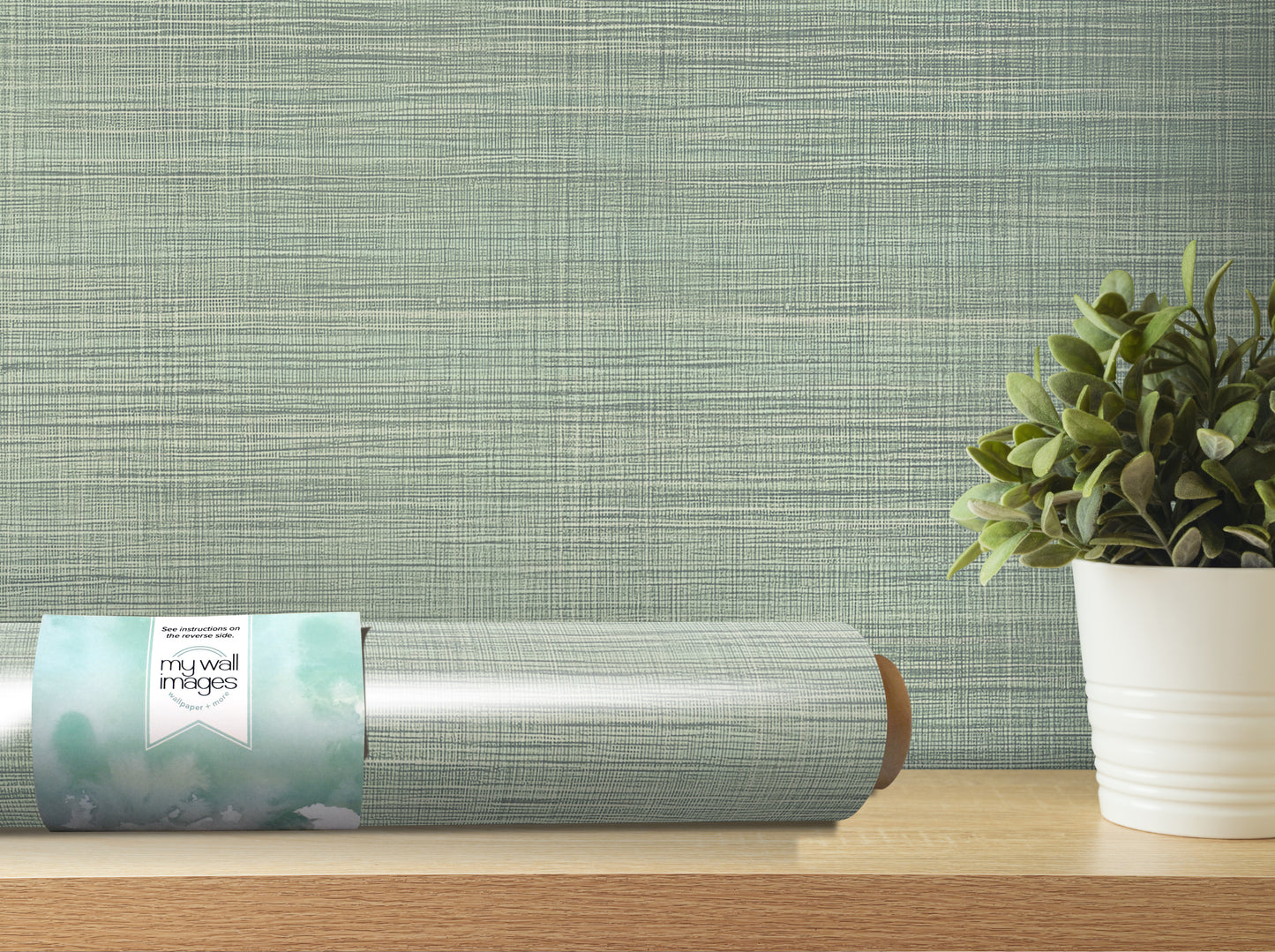 a roll of wallpaper on a shelf next to a potted plant.