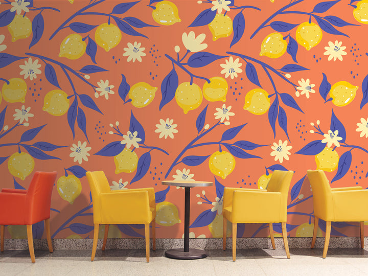 a vibrant and colorful wall with a repeating pattern of yellow lemons and blue leaves. In front of the wall, there are four yellow chairs arranged in a row, creating a cozy seating area.