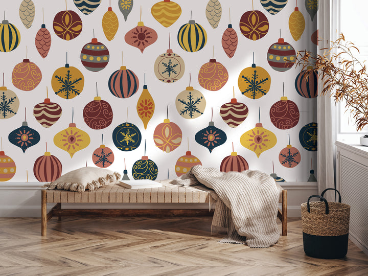 a wall decorated with a pattern of colorful Christmas ornaments, including baubles, stars, and snowflakes, creating a festive and holiday atmosphere. In the foreground, there is a bench with a blanket draped over it, and a woven basket is placed nearby.