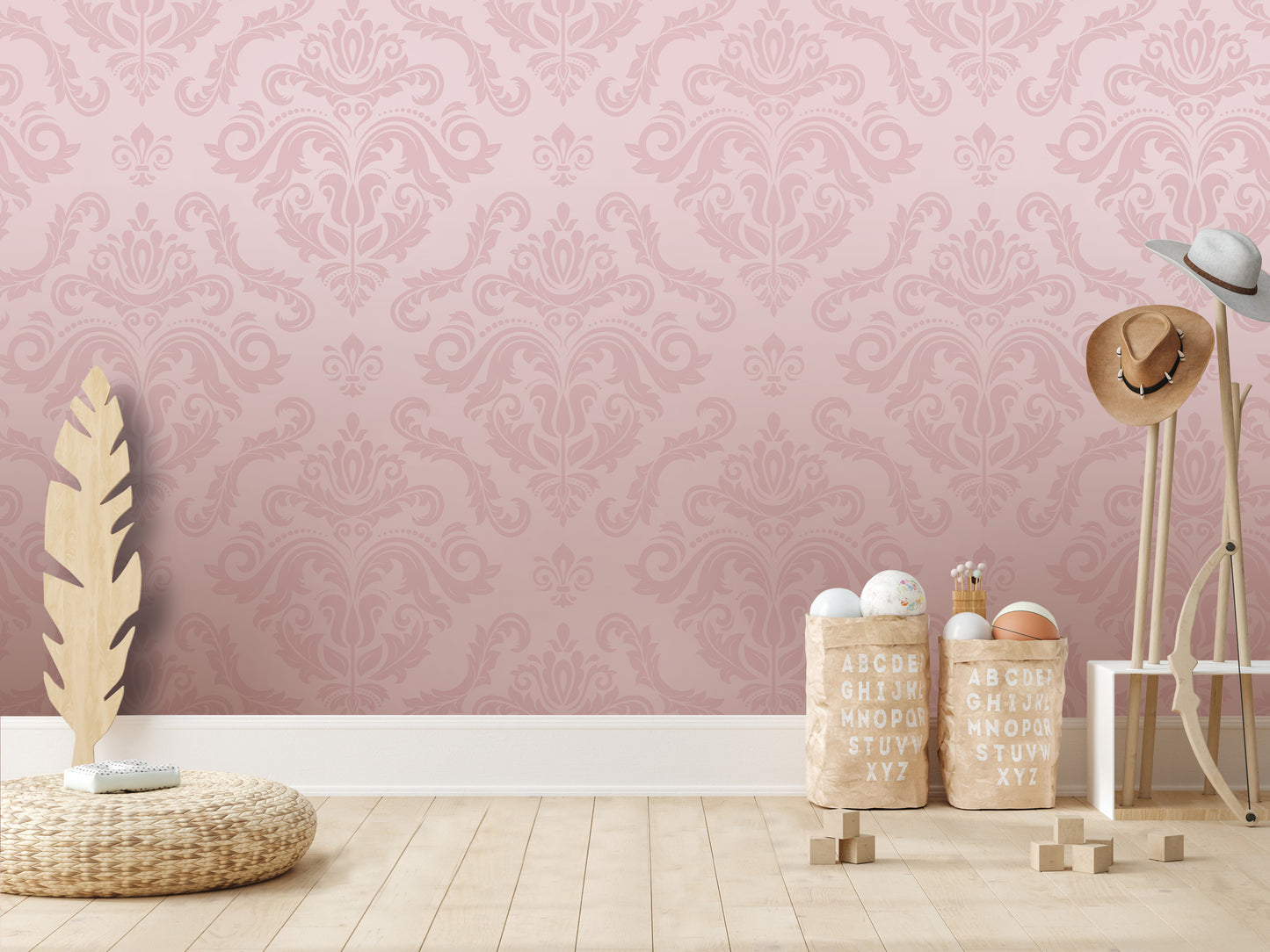 a pink wall with a decorative pattern, a wicker basket, a wooden stand with hats, and a set of alphabet blocks on a wooden floor.