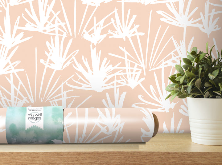 a roll of wallpaper with a white floral pattern on it, placed on a wooden shelf next to a potted plant.