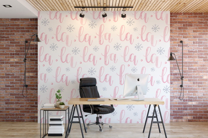 a modern office space with a desk, chair, and computer setup. The wall behind the desk has a repeating pattern of the word "la" in pink and white, creating a visually striking backdrop. The office appears to be well-lit and organized, with a focus on functionality and aesthetics.
